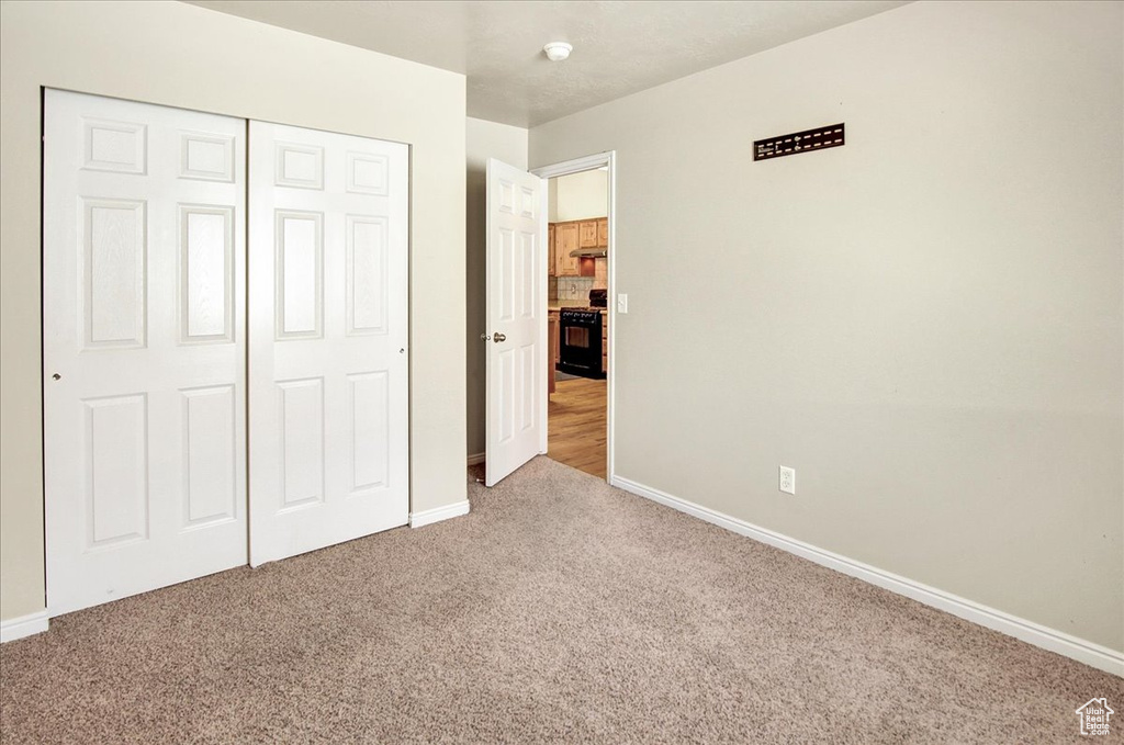 Unfurnished bedroom featuring a closet and carpet floors
