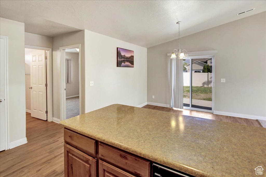 Kitchen with a notable chandelier, decorative light fixtures, and light hardwood / wood-style floors