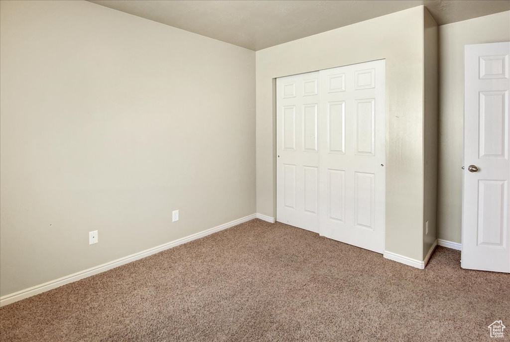 Unfurnished bedroom with carpet flooring and a closet