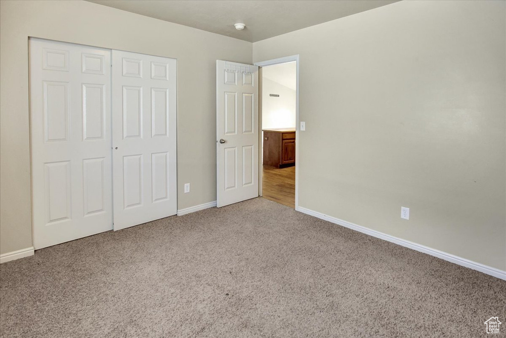 Unfurnished bedroom with a closet and carpet floors