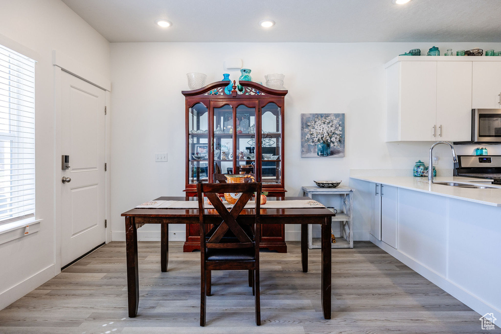 Dining room featuring a wealth of natural light, sink, and light wood-type flooring