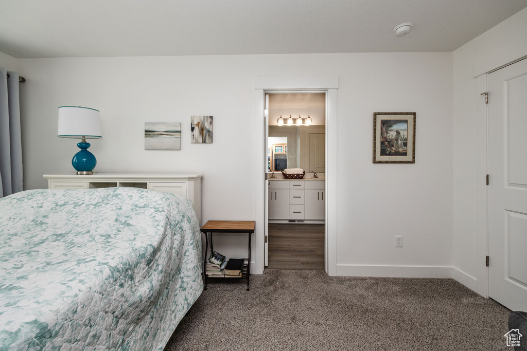 Bedroom featuring ensuite bathroom and carpet floors