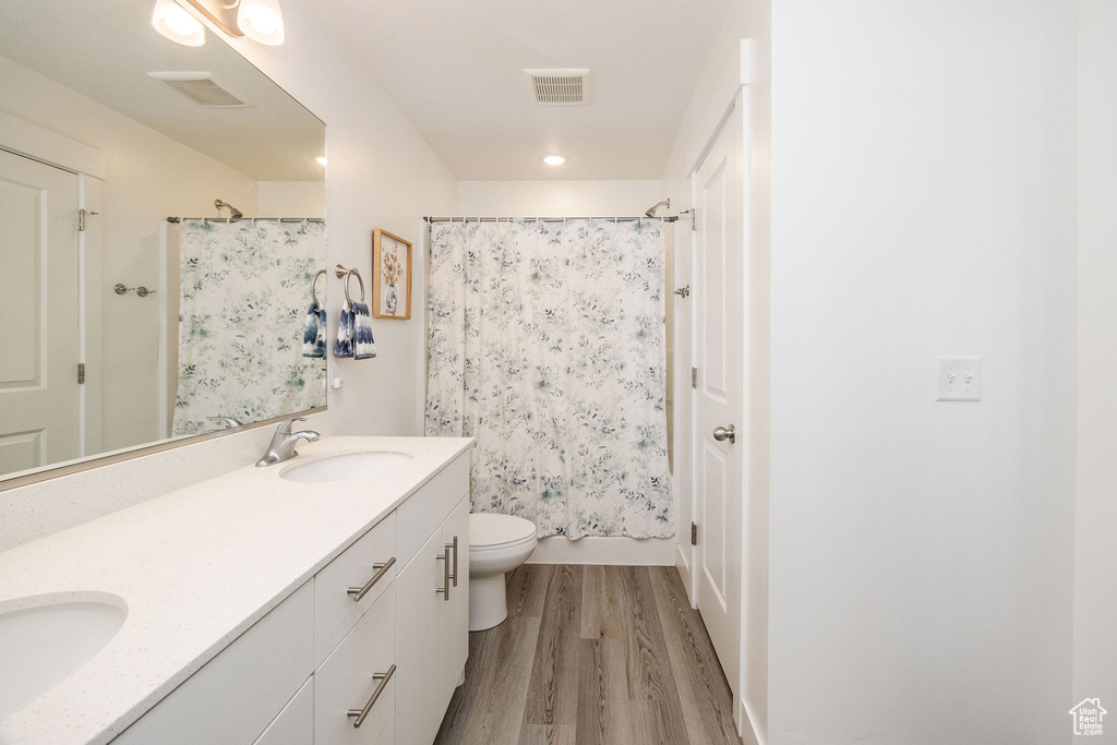 Bathroom with wood-type flooring, toilet, and vanity