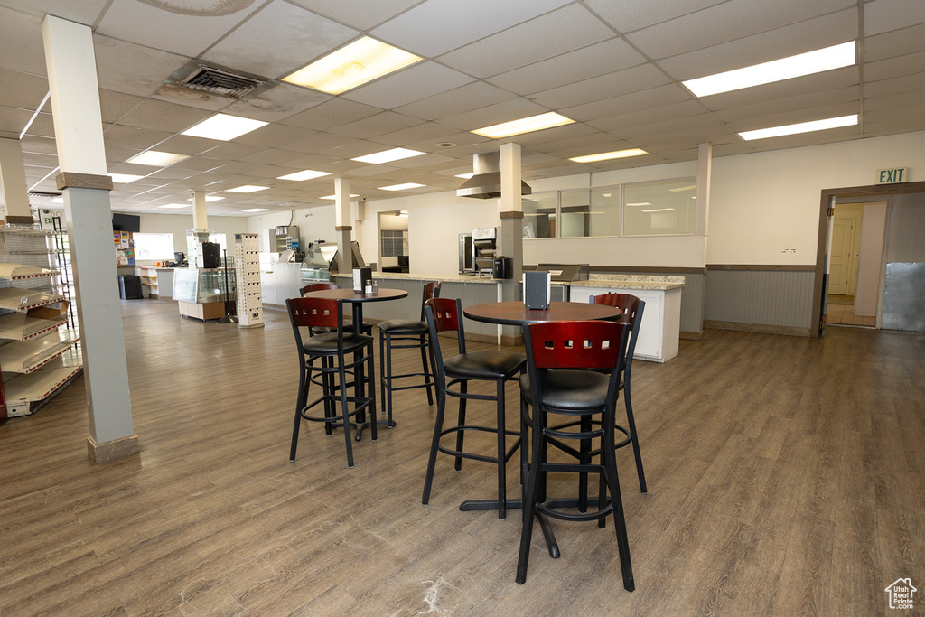 Dining space with wood-type flooring and a drop ceiling