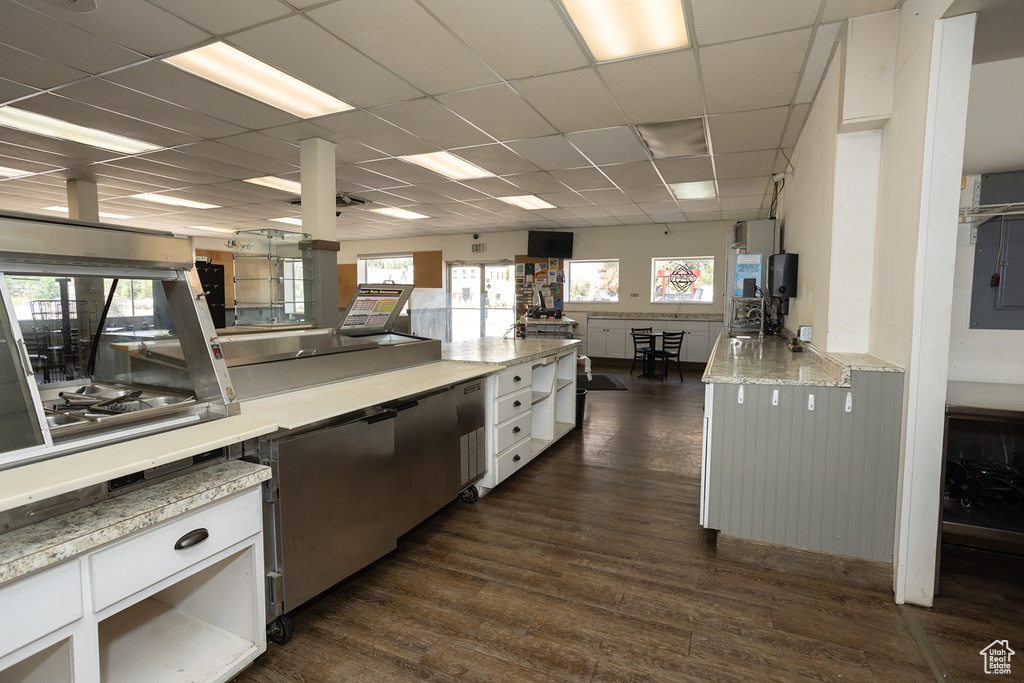 Kitchen featuring a paneled ceiling, dark hardwood / wood-style floors, and white cabinets