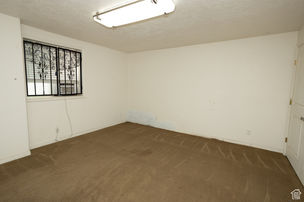 Spare room featuring a textured ceiling and carpet floors