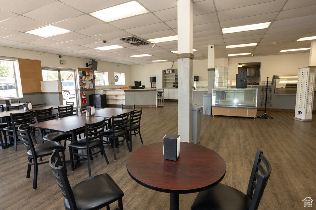 Dining area with hardwood / wood-style flooring and a drop ceiling