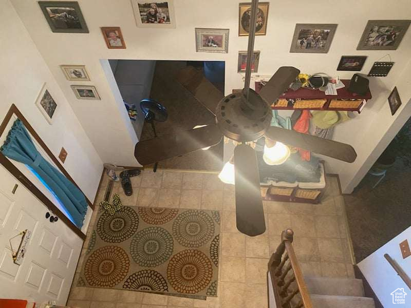 Living room with ceiling fan and light tile patterned floors