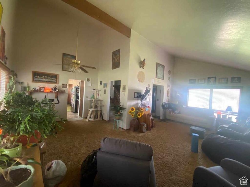 Carpeted living room with high vaulted ceiling and ceiling fan