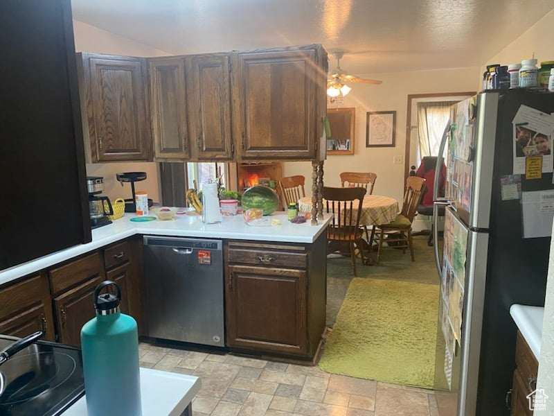 Kitchen featuring stainless steel appliances, dark brown cabinetry, ceiling fan, and kitchen peninsula