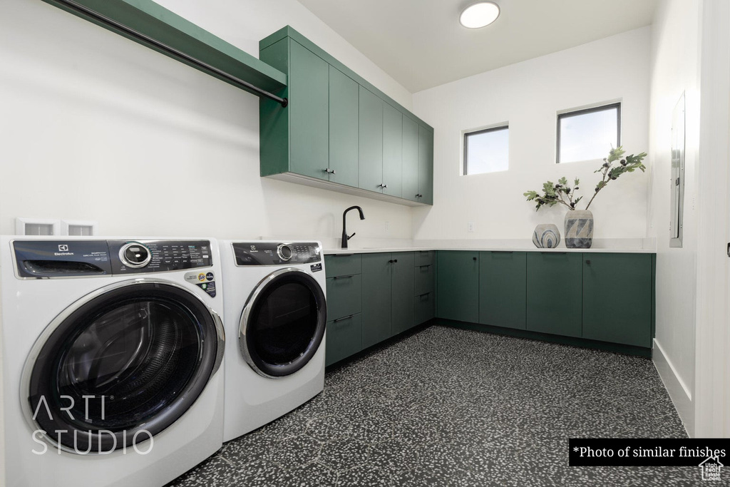 Clothes washing area with washing machine and clothes dryer, cabinets, and sink