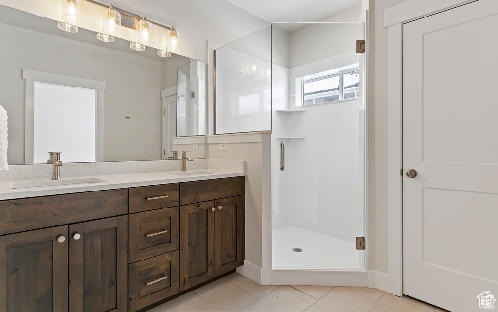 Bathroom with vanity, lofted ceiling, a shower with shower door, and tile patterned flooring