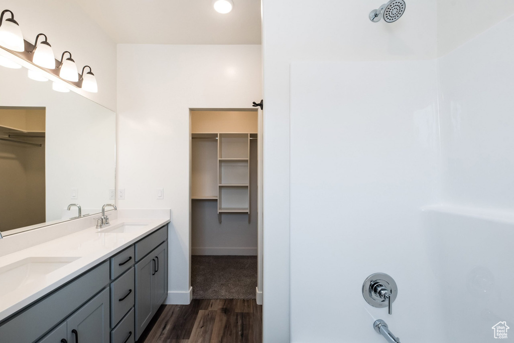 Bathroom featuring wood-type flooring, walk in shower, and vanity