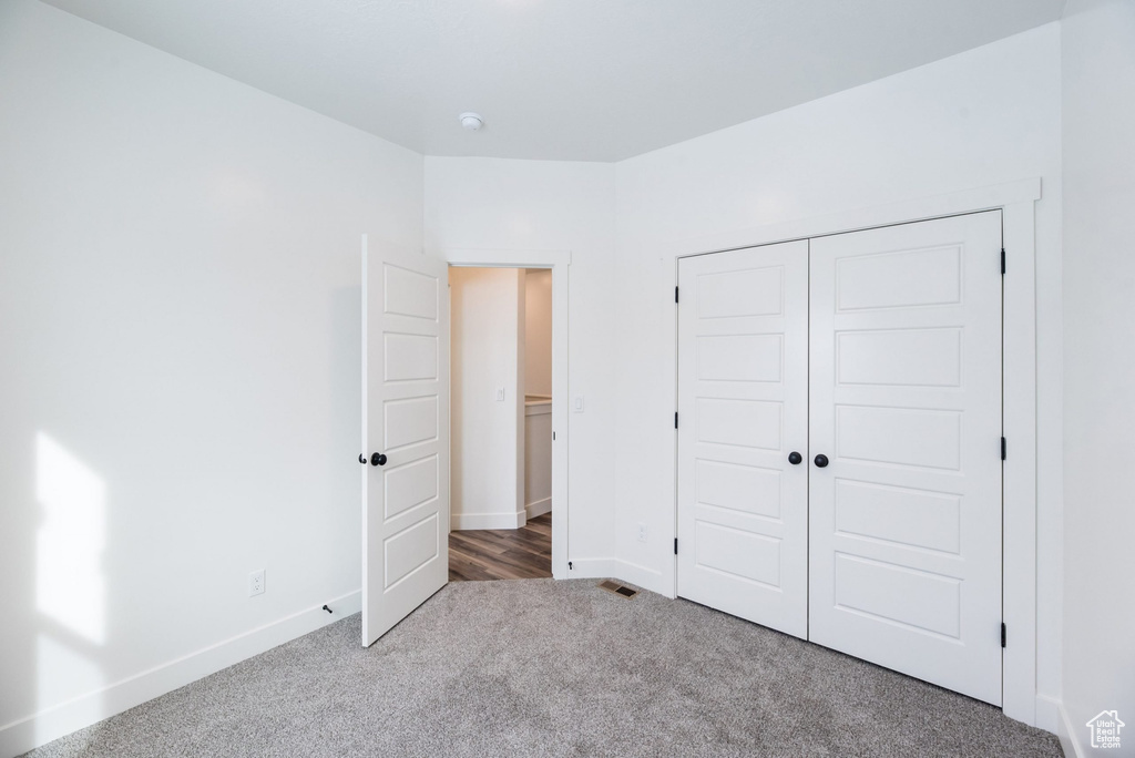 Unfurnished bedroom featuring a closet and carpet flooring