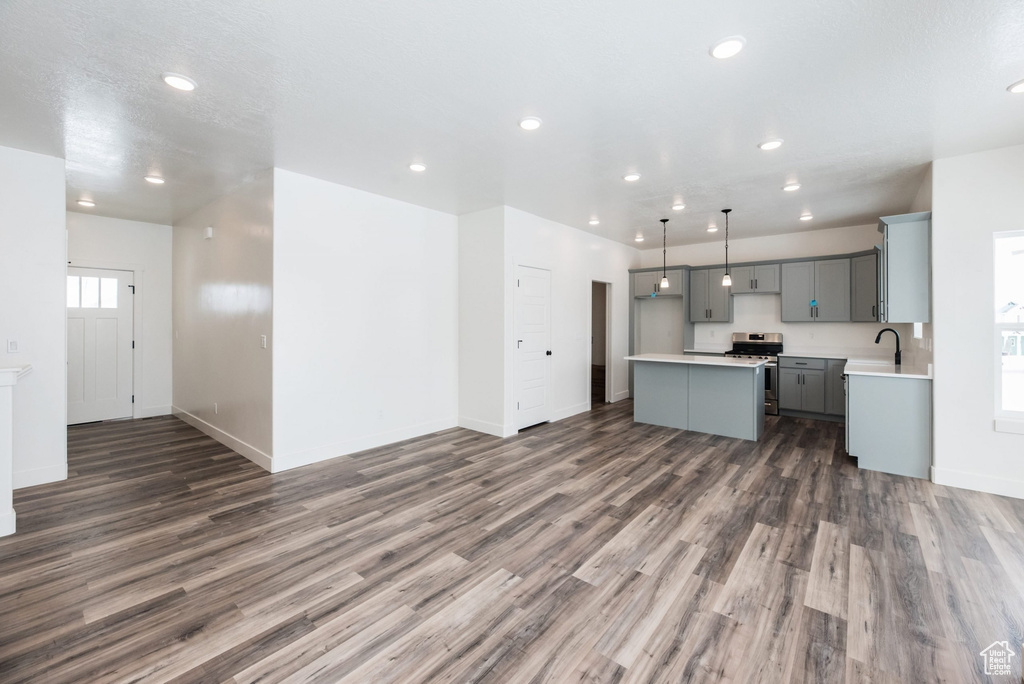 Kitchen featuring pendant lighting, a center island, dark hardwood / wood-style flooring, and stainless steel range oven