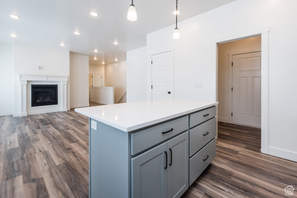 Kitchen with gray cabinets, pendant lighting, a kitchen island, and dark hardwood / wood-style floors