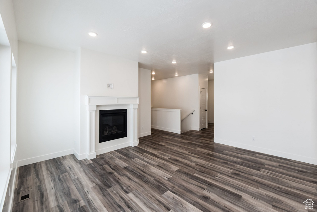 Unfurnished living room with dark wood-type flooring