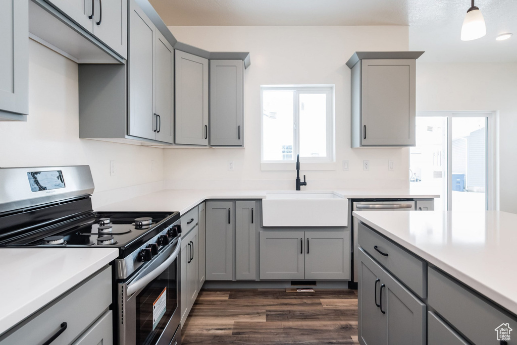 Kitchen featuring dark hardwood / wood-style floors, stainless steel range with gas cooktop, sink, and gray cabinets