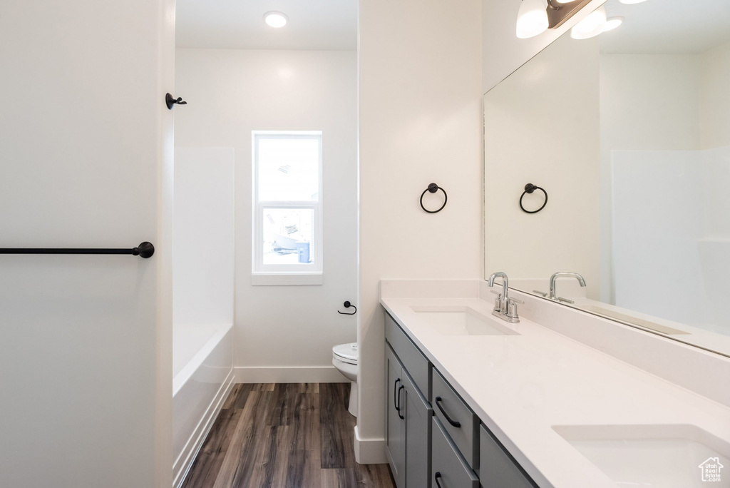 Full bathroom featuring hardwood / wood-style floors, separate shower and tub, toilet, and vanity