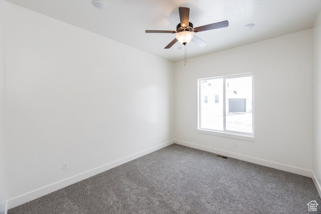 Carpeted spare room featuring ceiling fan