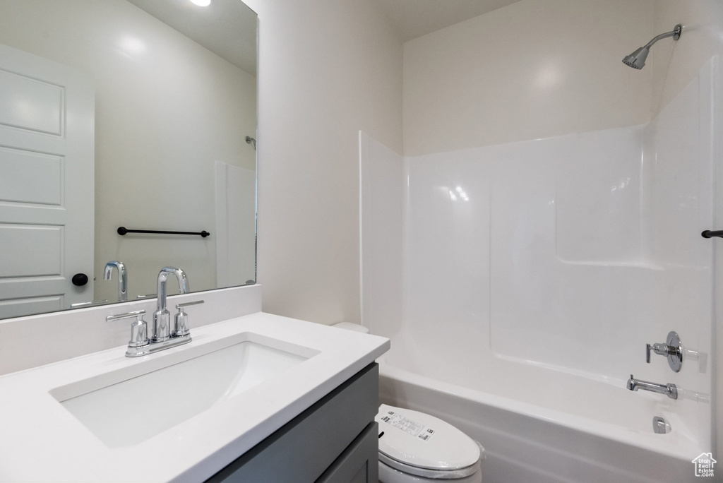 Full bathroom with vanity, toilet, and  shower combination