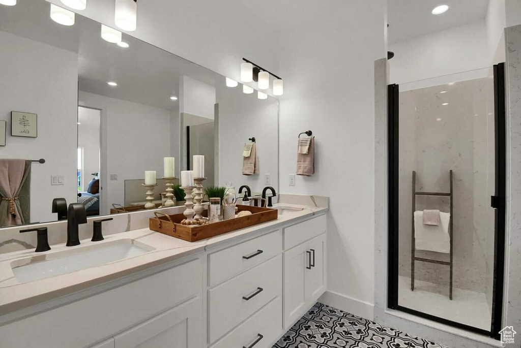 Bathroom featuring tile patterned flooring, walk in shower, and vanity