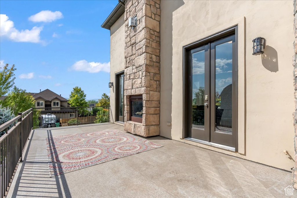 View of patio / terrace featuring an outdoor stone fireplace and french doors