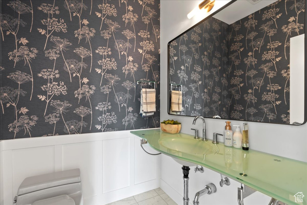 Bathroom featuring toilet, sink, and tile patterned floors