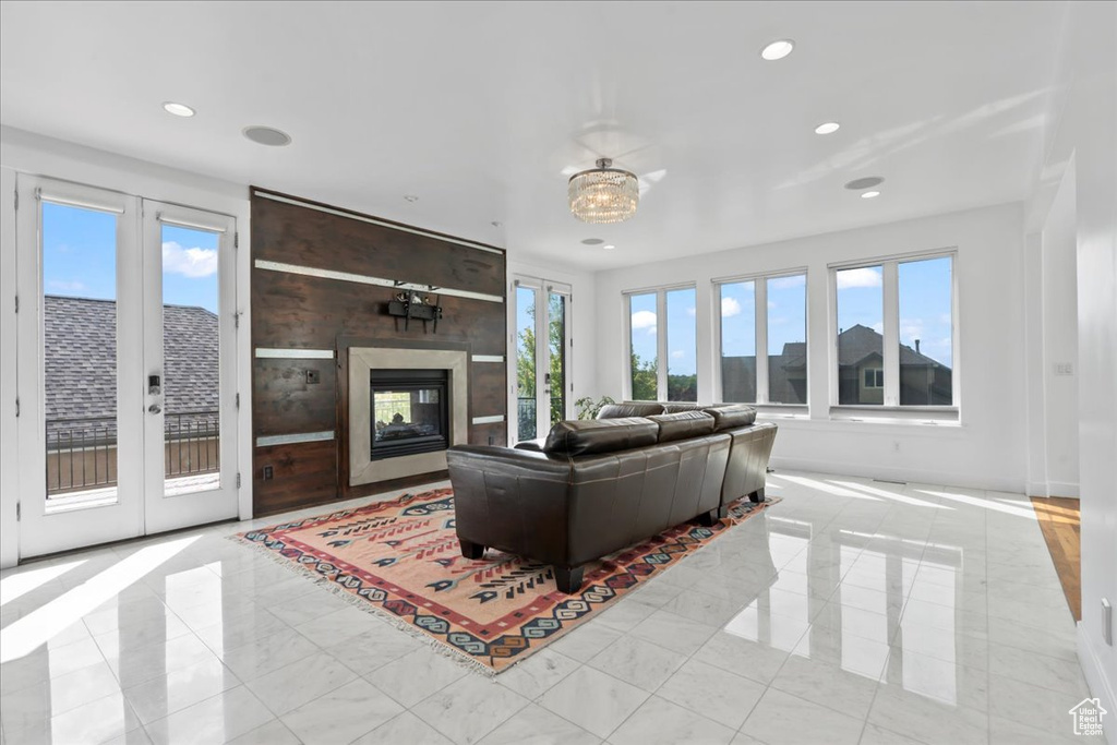 Living room featuring a wealth of natural light, french doors, and a multi sided fireplace