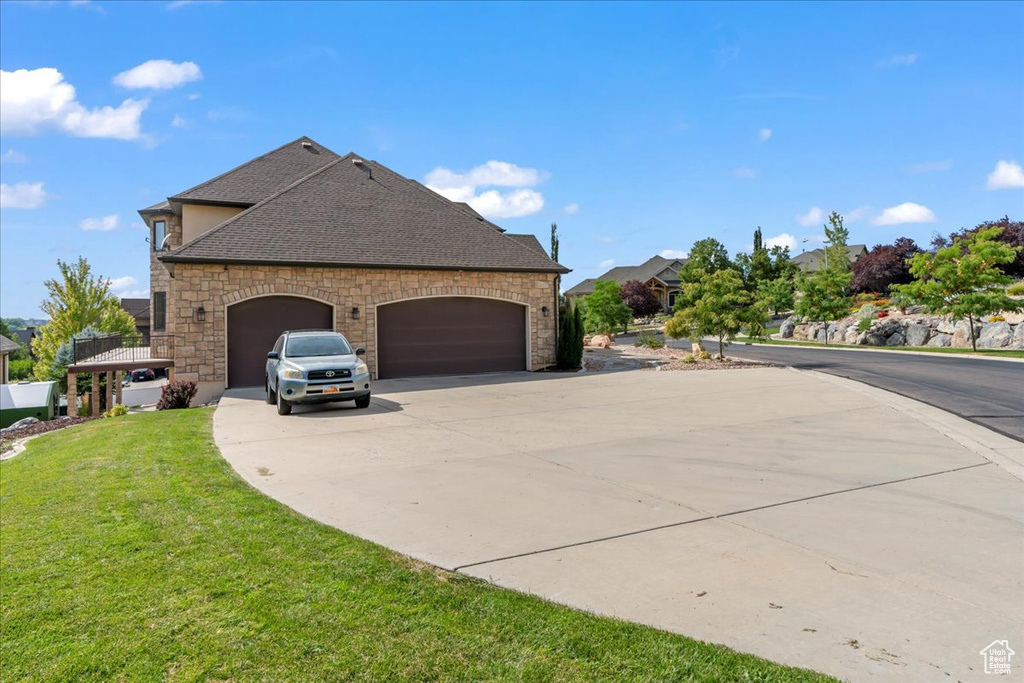 View of side of property featuring a yard and a garage