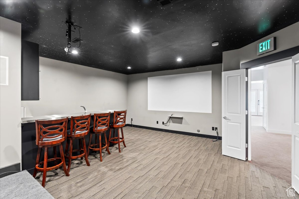 Carpeted home theater featuring bar