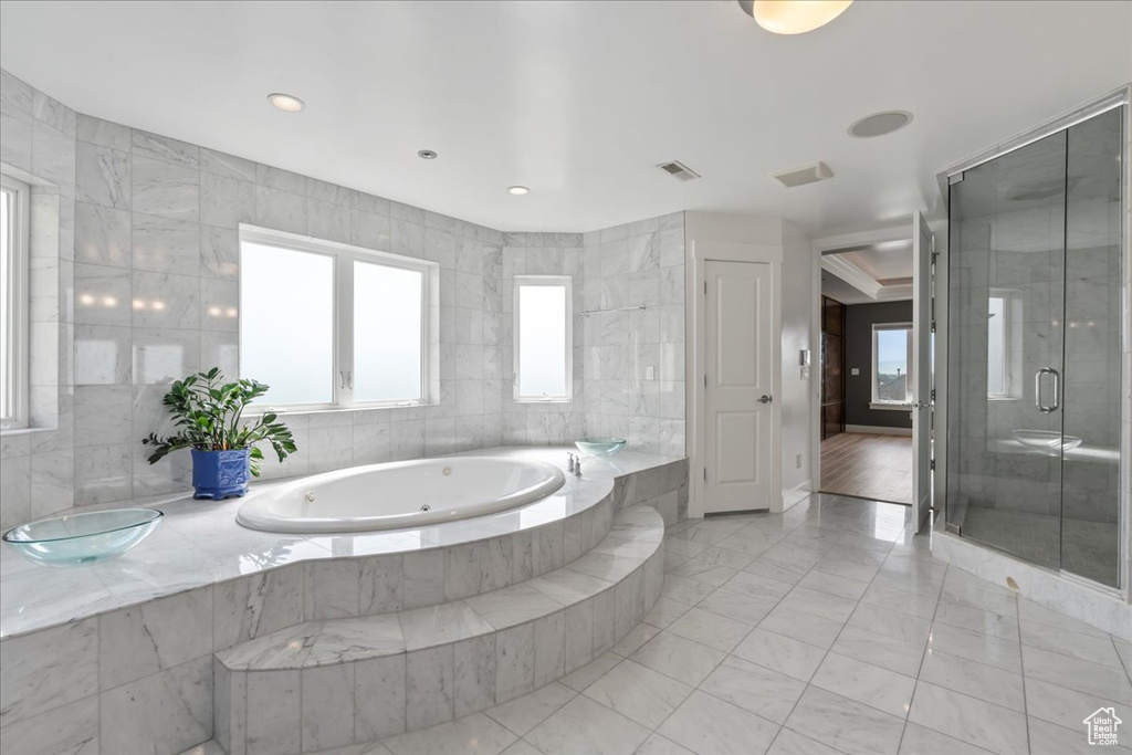 Bathroom featuring plus walk in shower and tile walls