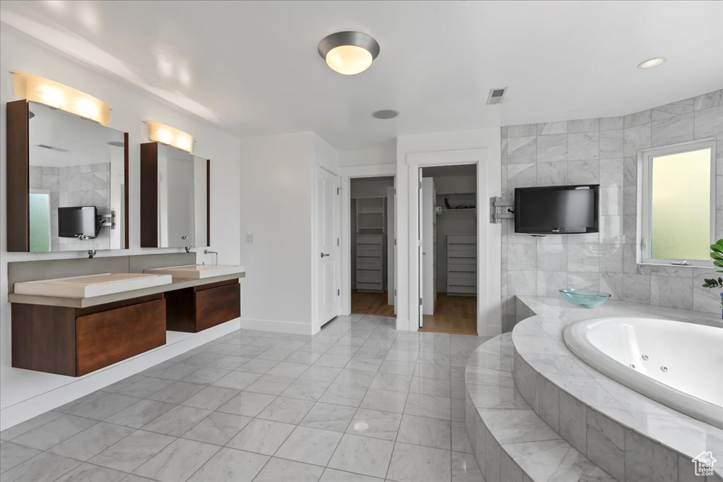 Bathroom with vanity and tiled bath