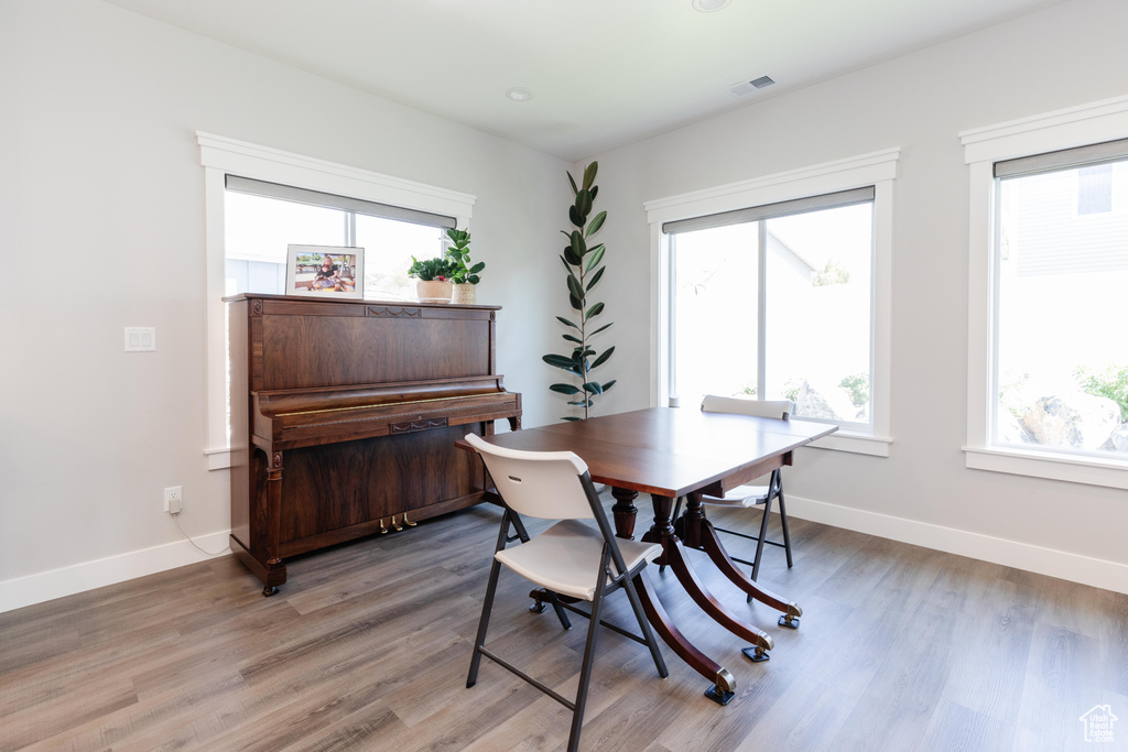 Dining area with a healthy amount of sunlight and hardwood / wood-style flooring