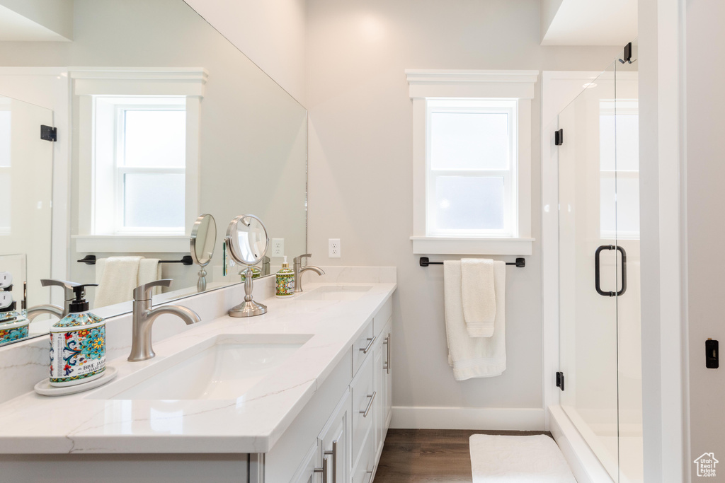 Bathroom featuring vanity, wood-type flooring, and a shower with shower door