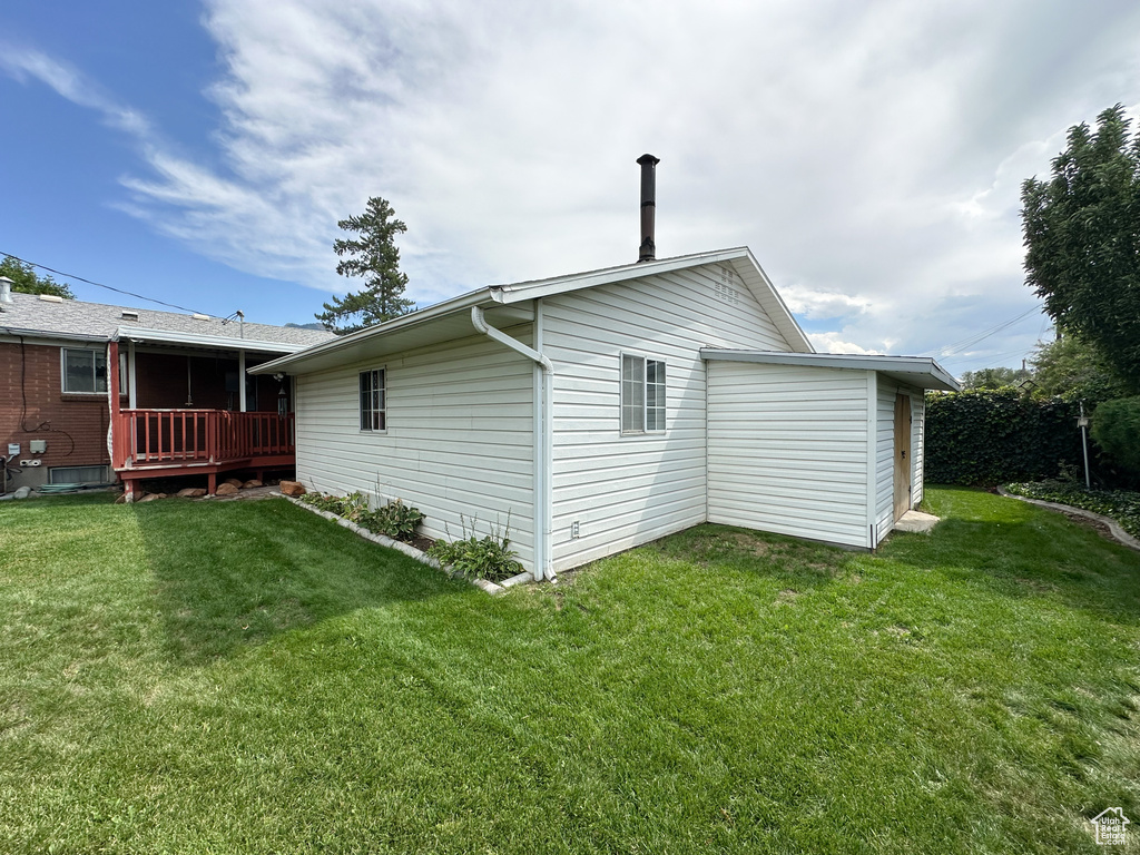 View of home\\\'s exterior featuring a deck and a lawn