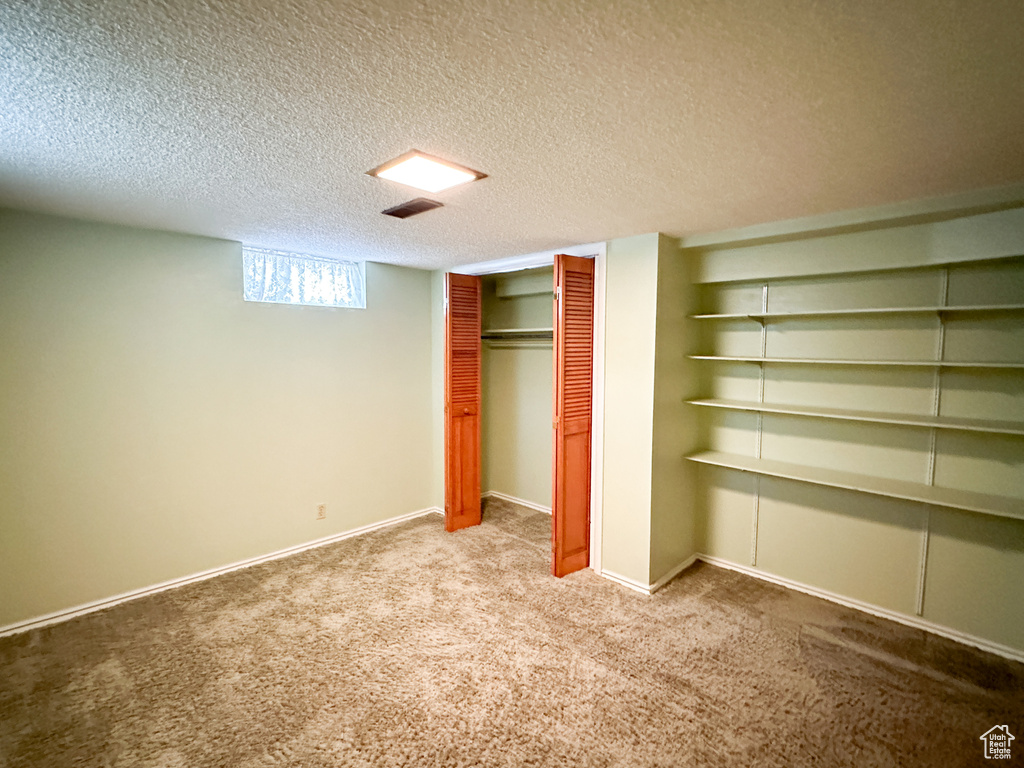 Unfurnished bedroom featuring a closet, a textured ceiling, and carpet floors