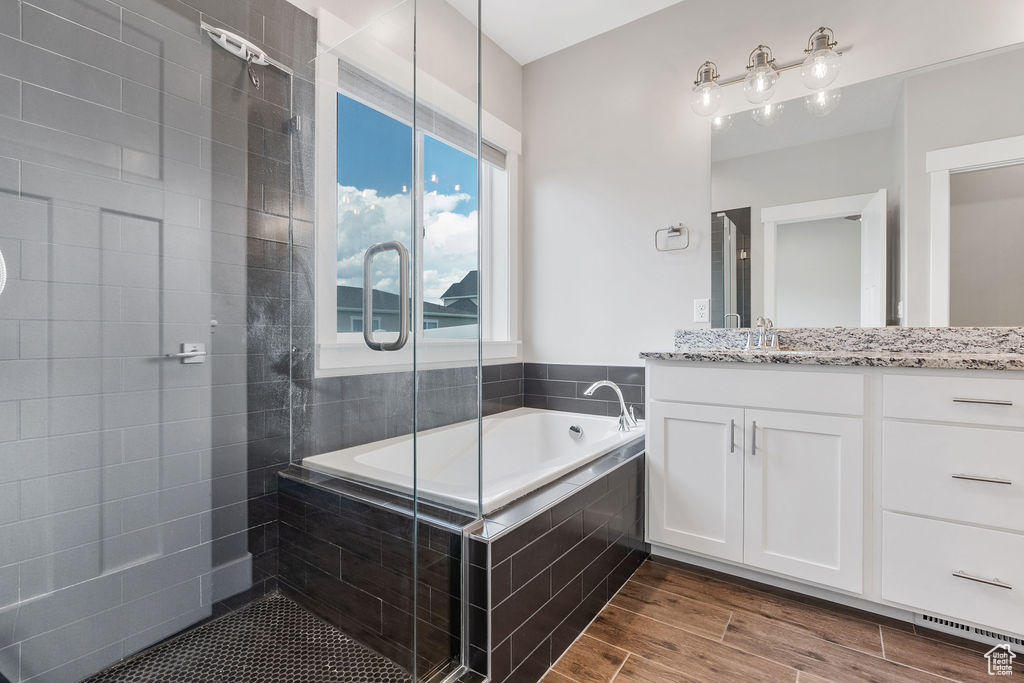 Bathroom featuring independent shower and bath, hardwood / wood-style flooring, and vanity