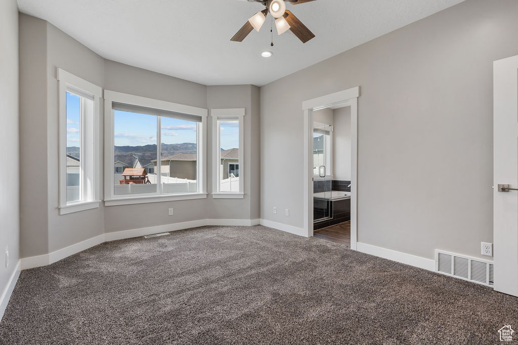 Carpeted spare room with ceiling fan