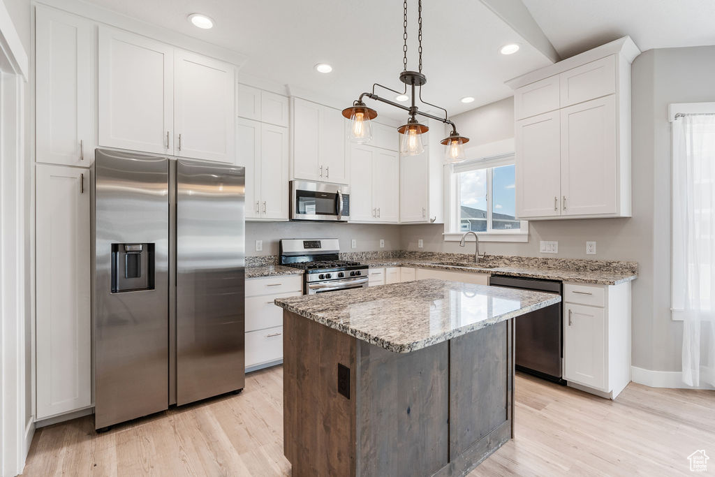 Kitchen with a center island, light hardwood / wood-style flooring, stainless steel appliances, white cabinetry, and sink