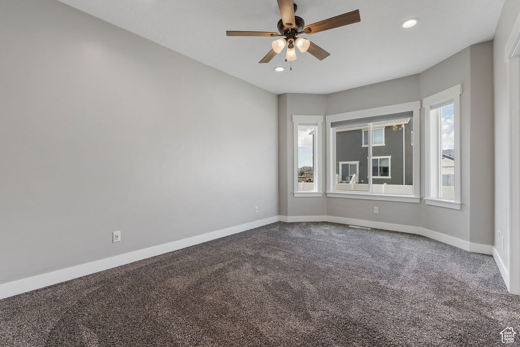 Carpeted spare room featuring ceiling fan