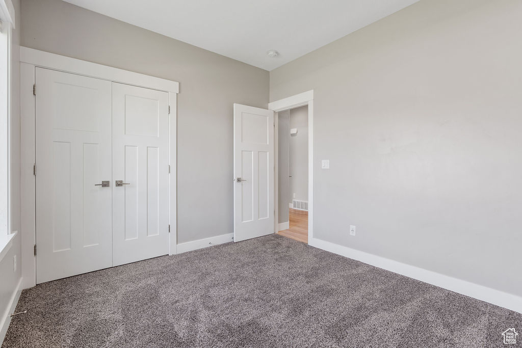 Unfurnished bedroom featuring carpet and a closet