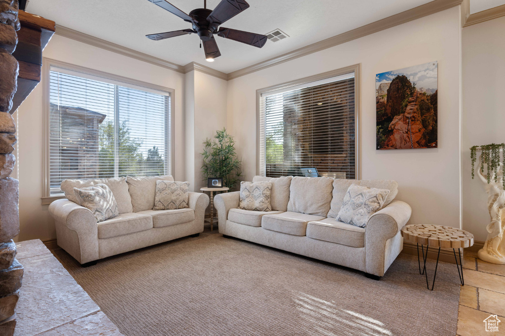 Living room featuring ceiling fan and ornamental molding