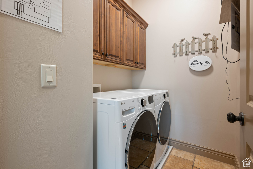 Laundry area featuring cabinets and washing machine and dryer