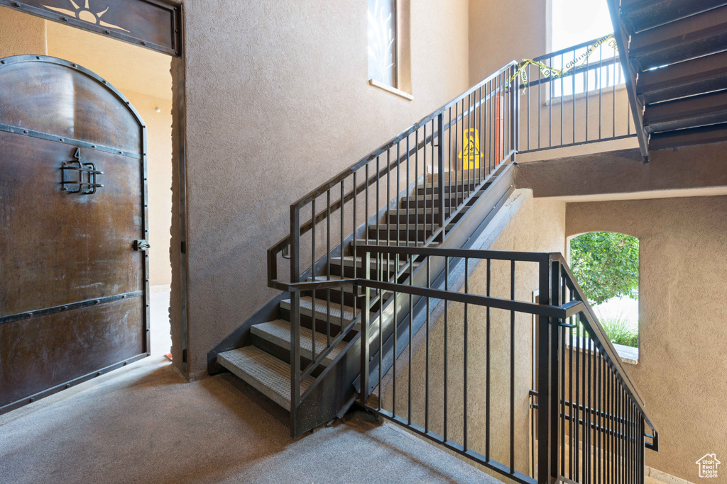 Stairs with a towering ceiling and carpet floors