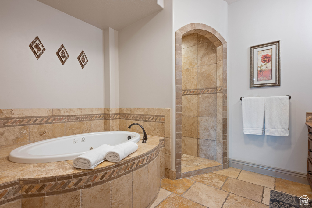 Bathroom featuring vanity and separate shower and tub