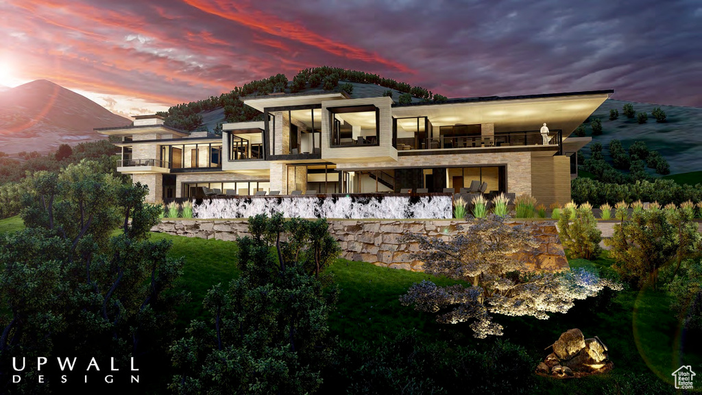 Back house at dusk featuring a balcony