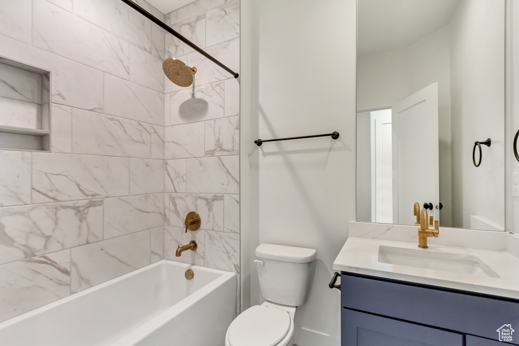 Full bathroom with vanity, toilet, and tiled shower / bath combo