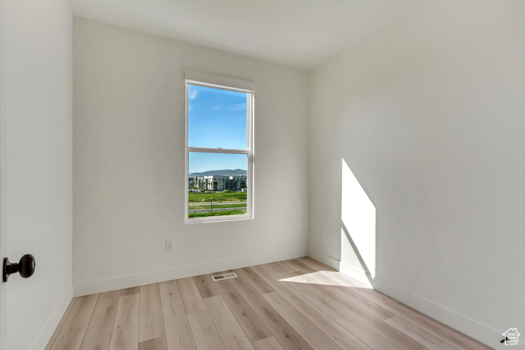 Empty room with light hardwood / wood-style floors