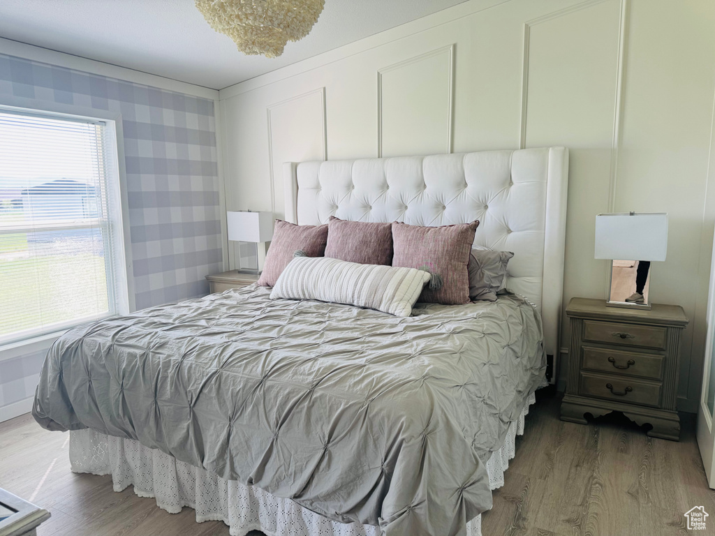 Bedroom with wood finished floors and multiple windows